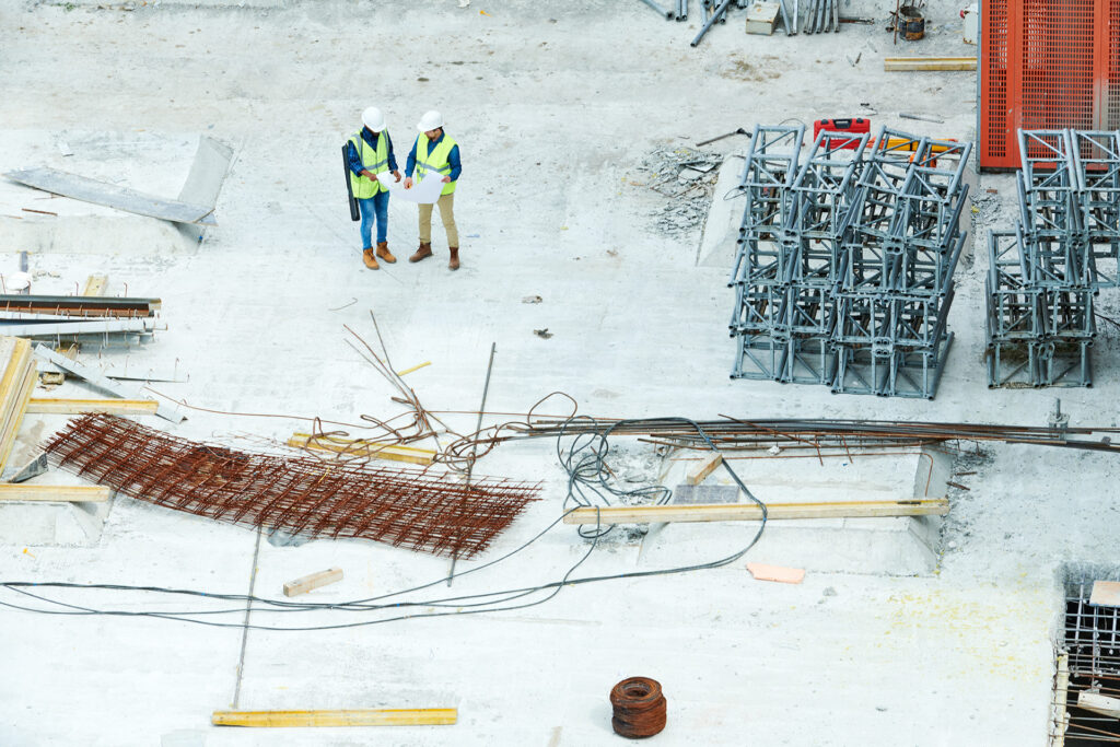 Wisconsin Weather Impacts Construction - two workers looking at blueprints surrounded by snow